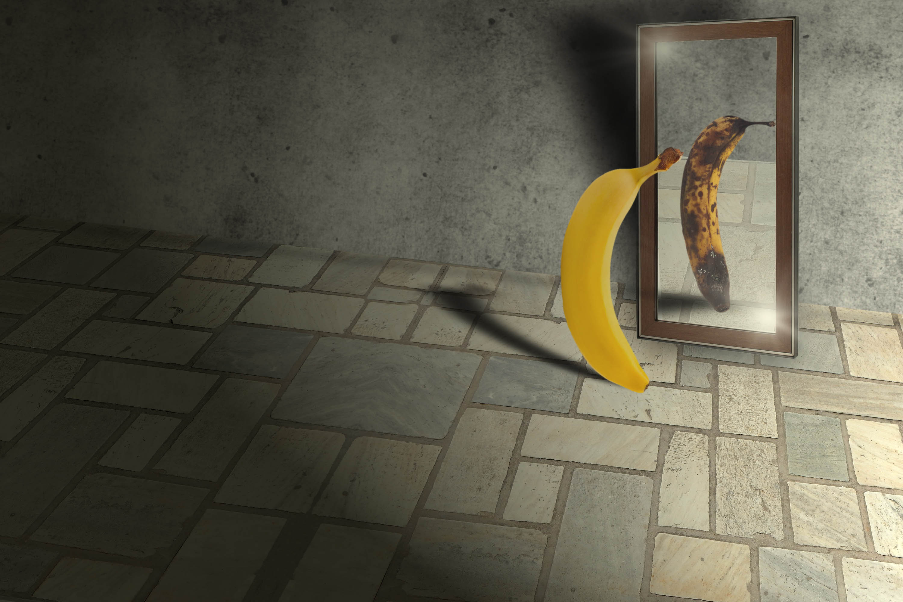A ripe banana looking in a mirror, rotten banana is reflected back A ripe banana looking in a mirror, rotten banana is reflected back
